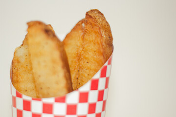 Potato wedges in a cup in studio lighting
