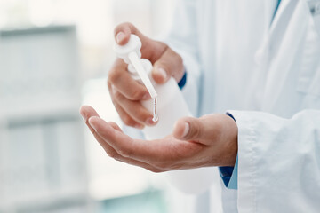 For my safety and for yours. Cropped shot of a scientist disinfecting his hands with hand sanitiser in a laboratory.