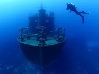 Garden poster Shipwreck scuba divers exploring and discovering the ship wreck underwater deep sea bottom metal on ocean floor