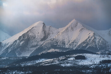 Fototapeta na wymiar Tatry Wysokie o świcie, zima, szczyty w chmurach, Karpaty, widok z przełęczy nad Łapszanką.