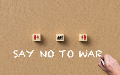 wooden blocks with soldier and people symbols and the message SAY NO TO WAR on paper background