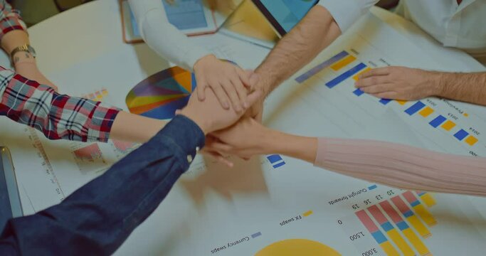 Close-up, a group of people at a team building, stacking hand on hand. Gesture of the winners, successful people stack hand on hand together, uniting the team. View from above. 4k, ProRes