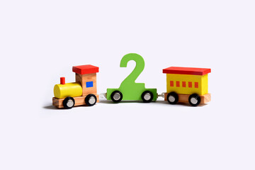 Very colorful toy wooden train that bears the number two . Birthday celebration love and happiness