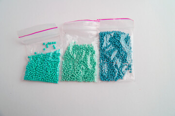Set of multi-colored beads and beads in a mini plastic bag for embroidery needlework