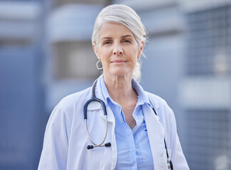 Healthcare is in my blood. Shot of a mature female doctor standing with her arms crossed against a city background.