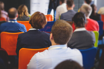 Audience at the conference hall listens to lecturer, people on a congress together listen to speaker on stage at master-class, corporate business seminar