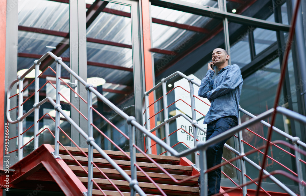 Poster i got the job. shot of a handsome young man using his mobile phone while sitting on the steps of an 