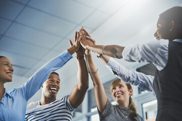 Were going to make success ours. Closeup shot of a group of businesspeople high fiving each other in an office.