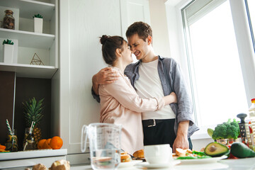 Couple hugging while standing in the kitchen wanting to make breakfast. Cooking, together, kitchen, relationship. Healthy food. Activity relationship