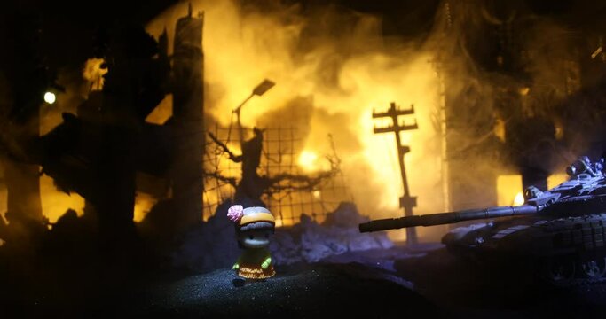 The death of children in the war. Russian war in Ukraine concept. Creative artwork of little doll lies on ground in burned out city. Selective focus