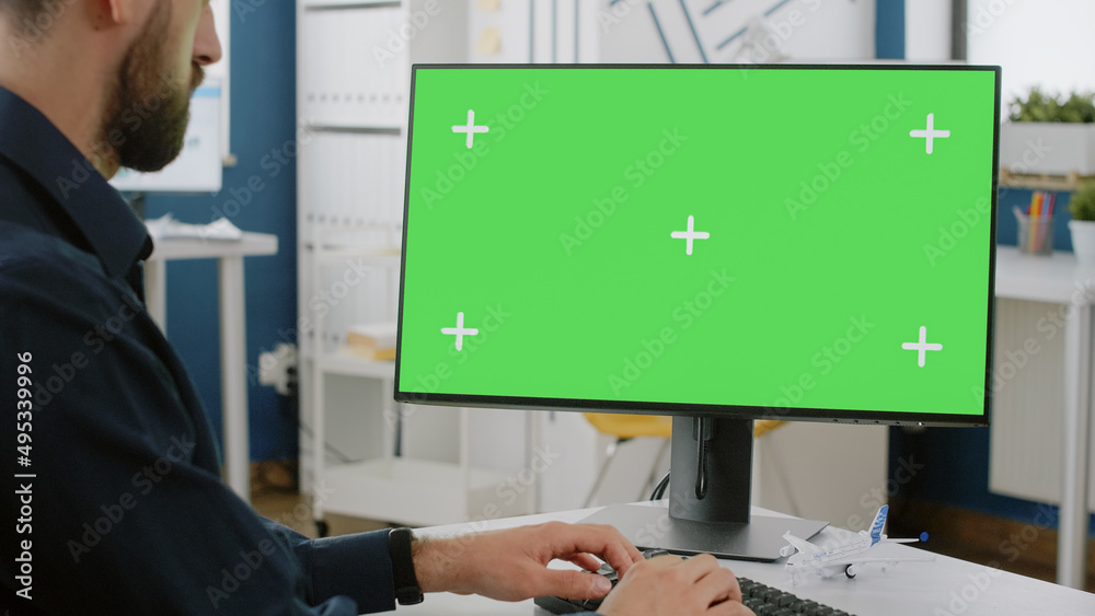 Poster close up of man typing on keyboard with green screen on monitor. business entrepreneur using compute