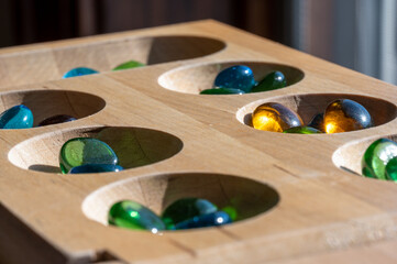 Selective focus on glass beads on a wooden mancala board