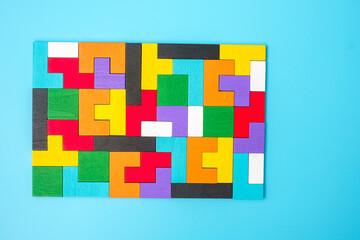 colorful wood puzzle pieces on blue background, geometric shape block. Concepts of logical thinking, Conundrum, solutions, rational, strategy, world logic day and Education