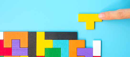 colorful wood puzzle pieces on blue background, geometric shape block. Concepts of logical...