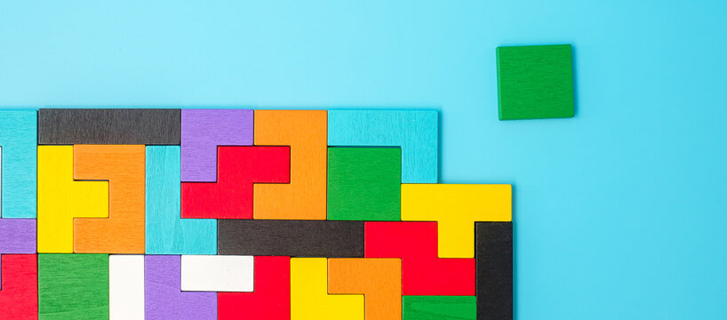 colorful wood puzzle pieces on blue background, geometric shape block. Concepts of logical thinking, Conundrum, solutions, rational, strategy, world logic day and Education