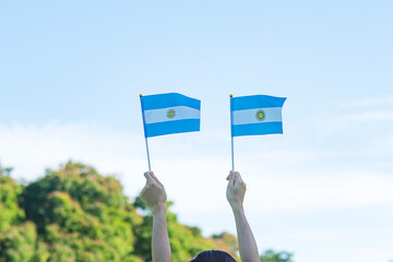 hand holding Argentina flag on nature background. 9th July of Independence day, 25th May of...