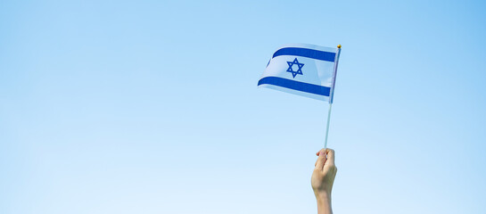 hand holding Israel flag on nature background. Israel Independence day and happy celebration...