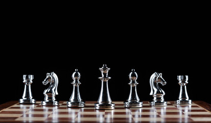 Silvery chess figures standing on chessboard