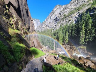 Tourists admire the rainbow created from mist coming from Vernal Falls at Yosemite National Park