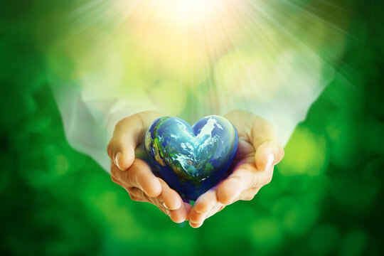 Earth crystal glass globe ball in Heart Shape in human hands,save clean planet,  World Earth Day Concept.