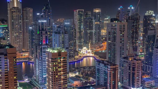 Dubai Marina skyline with Mohammad Bin Ahmed Al Mulla mosque aerial timelapse at night.