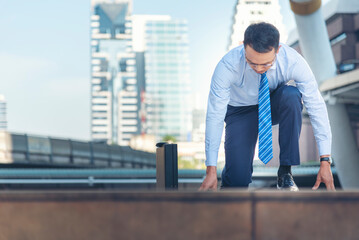 Businessman start kneeling city street race business goal winner challenge. Asian man look at camera smile face wear glasses. Man happiness time start up a business goal. Businessman race concept