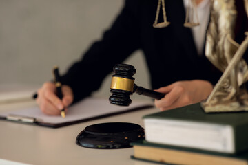 Attractive young lawyer in office Business woman and lawyers discussing contract papers with brass scale on wooden desk in office. Law, legal services, advice, Justice and real estate concept.
