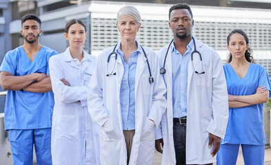 There isnt an illness we cant cure. Shot of a group of doctors standing against a city background. - obrazy, fototapety, plakaty