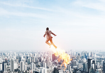 Businessman in suit and aviator hat flying in sky