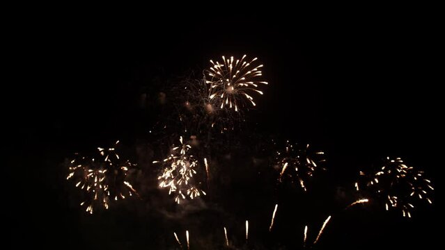Big real fireworks display celebration and colorful New year's eve. An abstract blur of real golden shining with bokeh lights in the night sky.