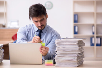 Young male employee and too much work in the office