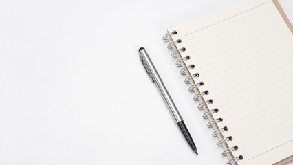 Silver pen and notebook blank page on the table top view copy space