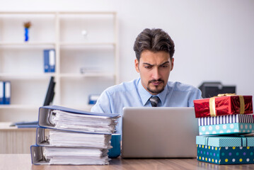 Young male employee celebrating birthday at workplace