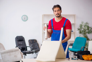 Young male carpenter working at workshop