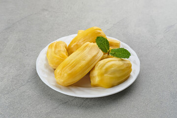 Fresh and ripe jackfruit served on a plate on a wooden table. Space for text.

