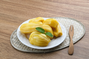Fresh and ripe jackfruit served on a plate on a wooden table. Space for text.
