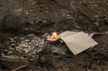 Burning in the fire of a torn notebook. The cover and the multi-colored sheets burn into gray ash.