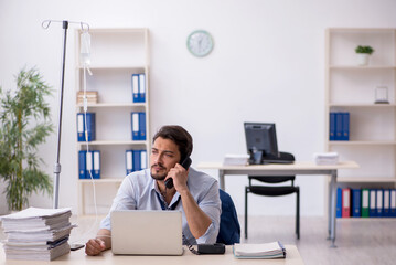 Young male employee suffering at workplace
