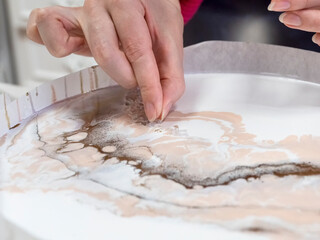 Technology process of creating a painting in style resin art, woman works with glass rhinestones...