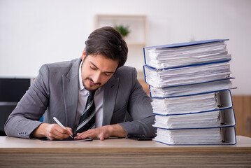 Young male employee unhappy with excessive work in the office