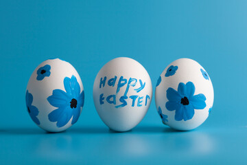 White eggs decorated with flowers on a blue background.