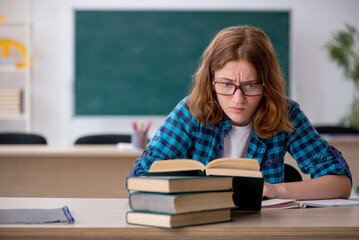 Young female student preparing for exam in the classroom