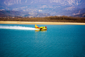 The firefighting plane takes off after filling the tanks