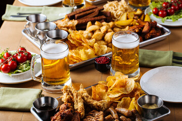 Table set with beer and salty snacks in a pub - obrazy, fototapety, plakaty