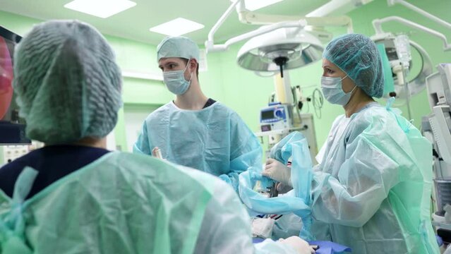 Endoscopic surgery. Surgeons perform surgery and look at the monitor screen in the operating room. Modern technologies in medicine.