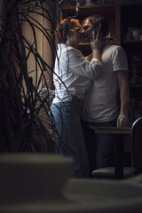 A couple in love in white shirts and jeans, a date in a pottery workshop, working together on one potter's wheel