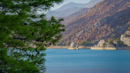 View from the slope to Oymapinar Dam through tree branches in Turkey