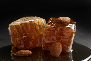 Organic honeycomb with dripping honey on black slate