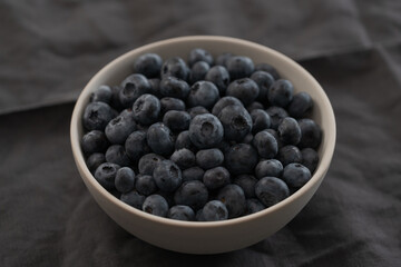 Blueberries in ceramic bowl on wood table