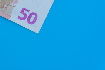 Fifty euro, money, banknote on a blue background (copy space).
